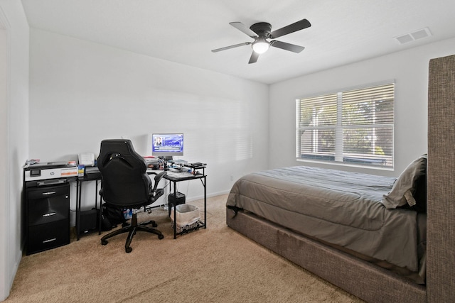 bedroom featuring a ceiling fan, visible vents, and light colored carpet