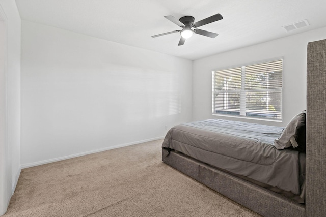 carpeted bedroom with a ceiling fan, visible vents, and baseboards