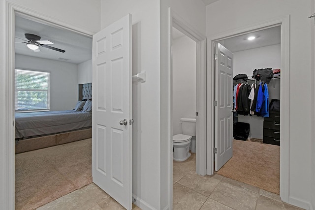 bathroom featuring a walk in closet, visible vents, toilet, ceiling fan, and ensuite bath