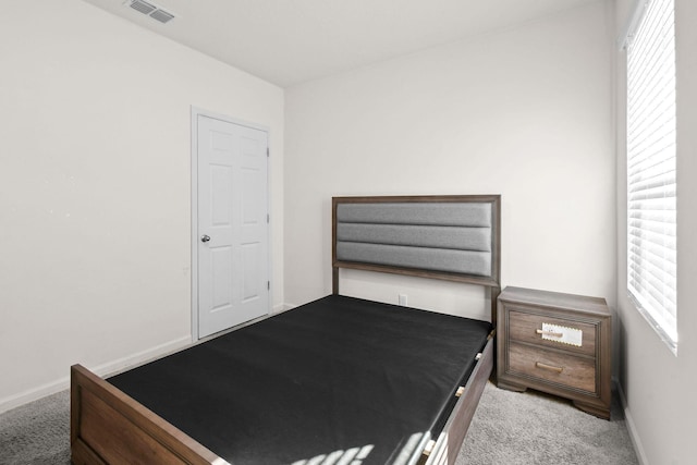 carpeted bedroom featuring visible vents and baseboards