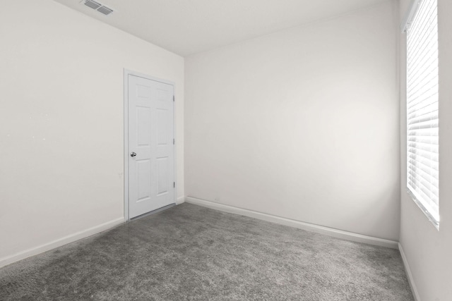 carpeted spare room with baseboards and visible vents