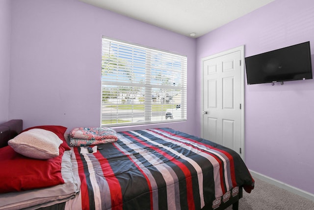 carpeted bedroom featuring baseboards