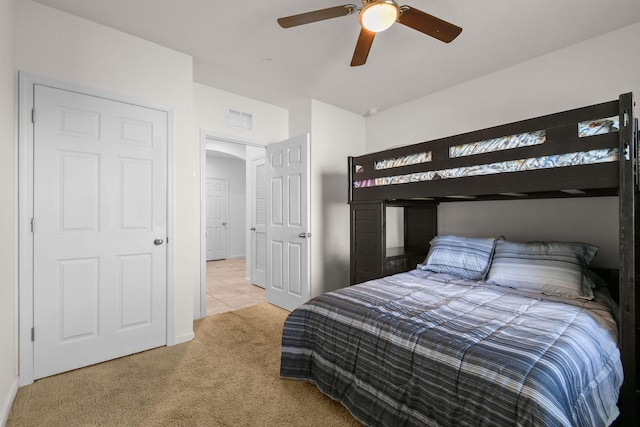 tiled bedroom featuring carpet floors, visible vents, and a ceiling fan