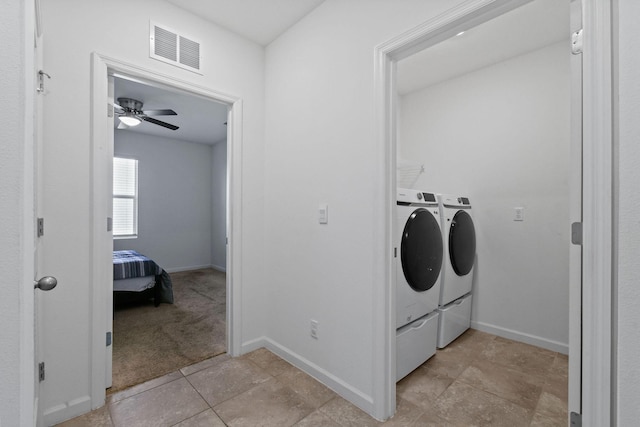 clothes washing area featuring laundry area, washer and clothes dryer, visible vents, and baseboards