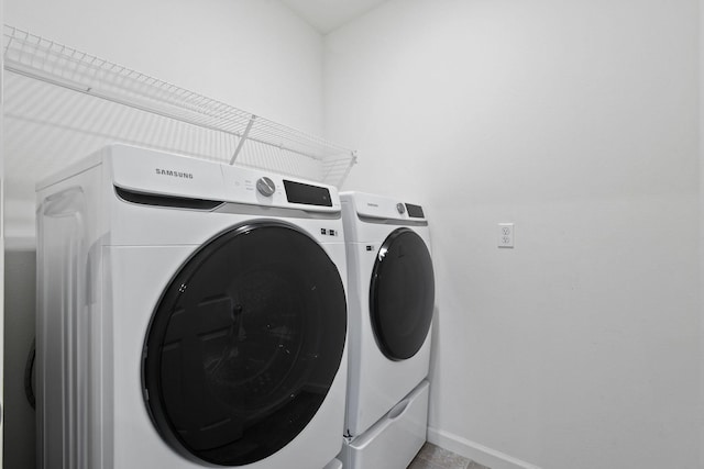 laundry room with laundry area, baseboards, and separate washer and dryer