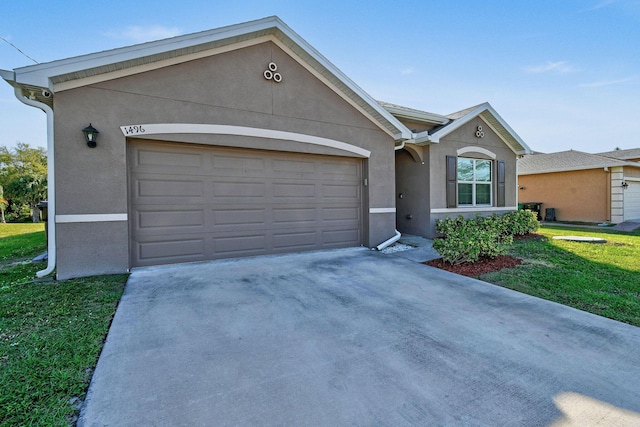 single story home featuring a garage, concrete driveway, a front yard, and stucco siding