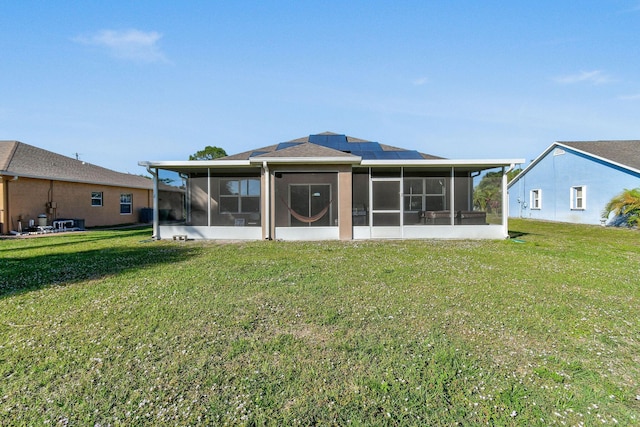 rear view of house with a sunroom and a yard