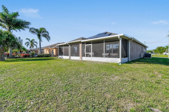 back of property featuring a sunroom, a yard, and central air condition unit