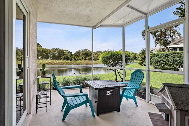 sunroom / solarium featuring a water view