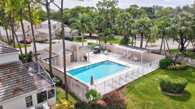 view of swimming pool with a yard, a patio area, and glass enclosure