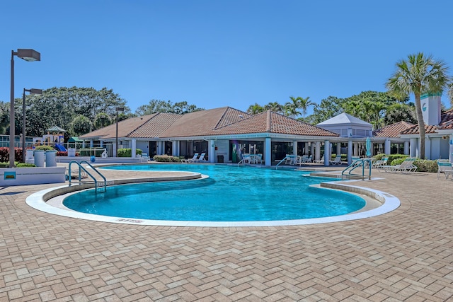 pool featuring a patio area and playground community