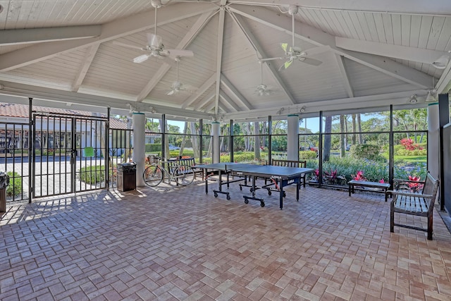 unfurnished sunroom featuring beam ceiling and a ceiling fan