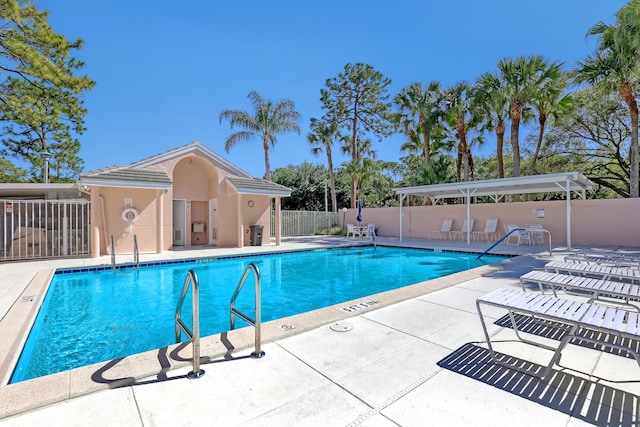 community pool featuring a patio and fence