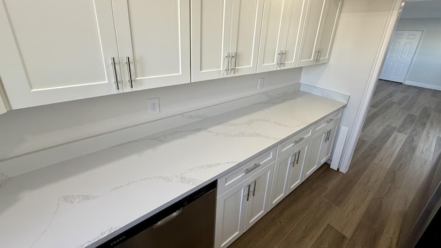 kitchen with light stone counters, white cabinetry, and dark wood-type flooring