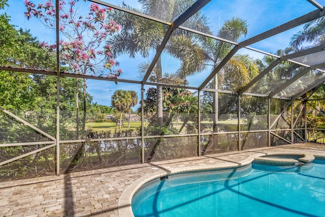 view of swimming pool with an in ground hot tub, a patio, and glass enclosure