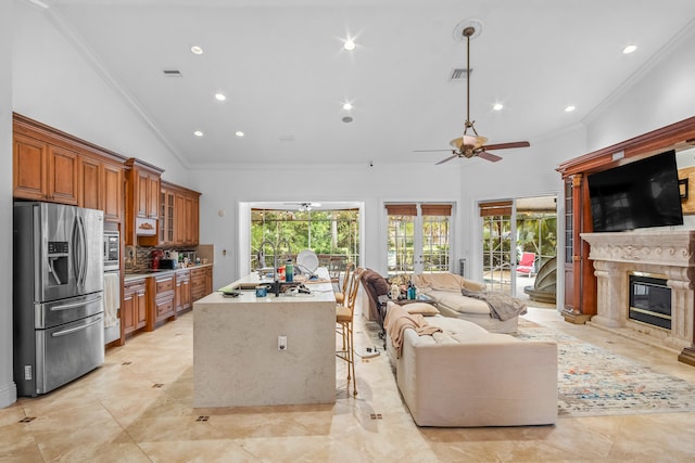 kitchen featuring stainless steel refrigerator with ice dispenser, lofted ceiling, a breakfast bar, tasteful backsplash, and a fireplace