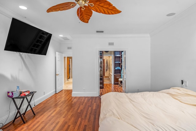 bedroom featuring hardwood / wood-style floors, crown molding, and ceiling fan