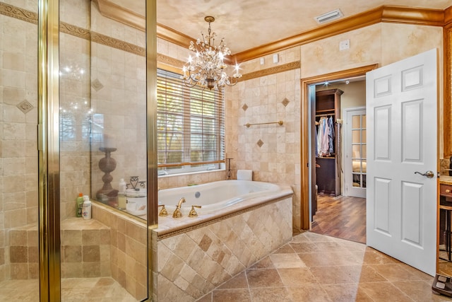 bathroom with wood-type flooring, tile walls, separate shower and tub, crown molding, and an inviting chandelier