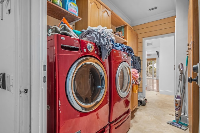 washroom featuring ornamental molding, wooden walls, and independent washer and dryer