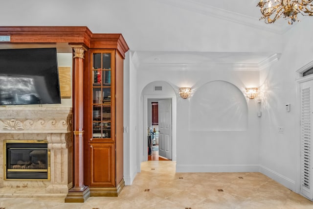 hallway with ornamental molding and a notable chandelier