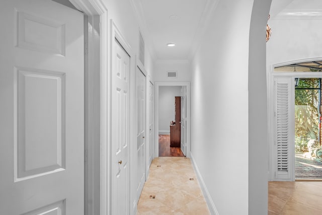 hall featuring ornamental molding and light tile patterned floors