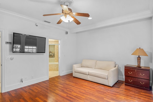 living room with ornamental molding, light hardwood / wood-style floors, and ceiling fan