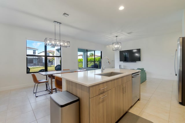 kitchen with a large island, sink, light tile patterned floors, appliances with stainless steel finishes, and a chandelier