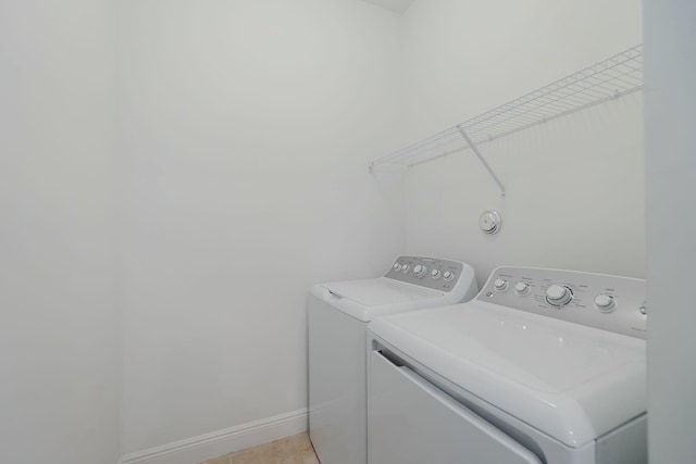 clothes washing area featuring washer and clothes dryer and light tile patterned flooring