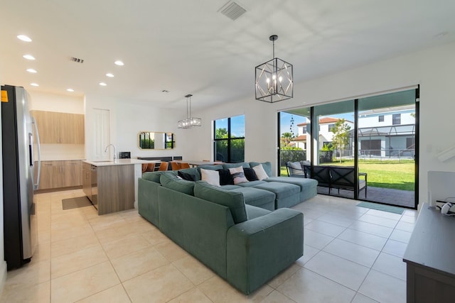 living room with sink, light tile patterned floors, and a chandelier