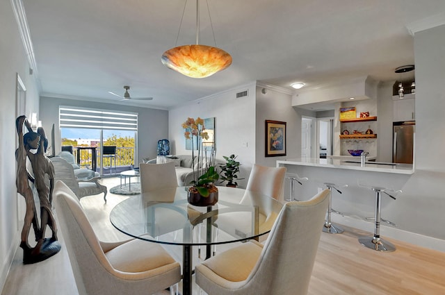 dining space featuring crown molding, ceiling fan, sink, and light hardwood / wood-style floors