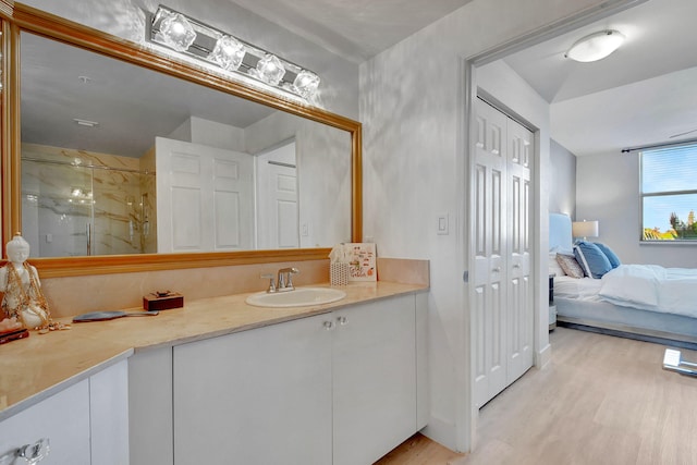 bathroom with vanity, hardwood / wood-style floors, and a shower with door