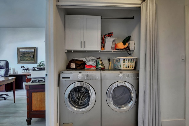 laundry room with cabinets, independent washer and dryer, and light hardwood / wood-style flooring