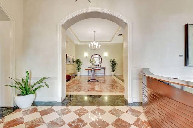 interior space with a notable chandelier and a tray ceiling