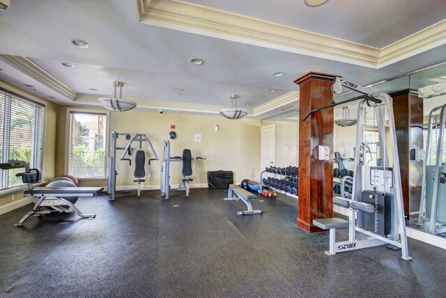 gym featuring crown molding and a tray ceiling