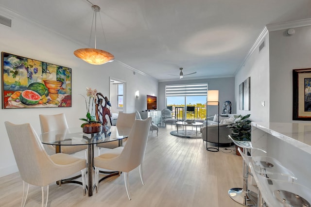 dining space featuring crown molding, ceiling fan, and light hardwood / wood-style floors