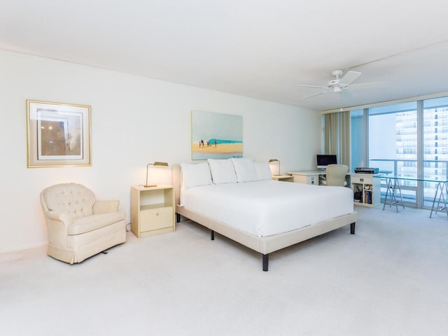 carpeted bedroom featuring a wall of windows and ceiling fan