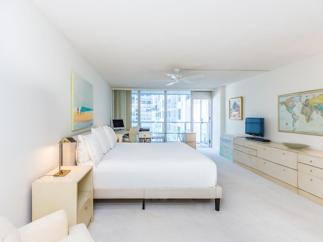 carpeted bedroom with a wall of windows and ceiling fan