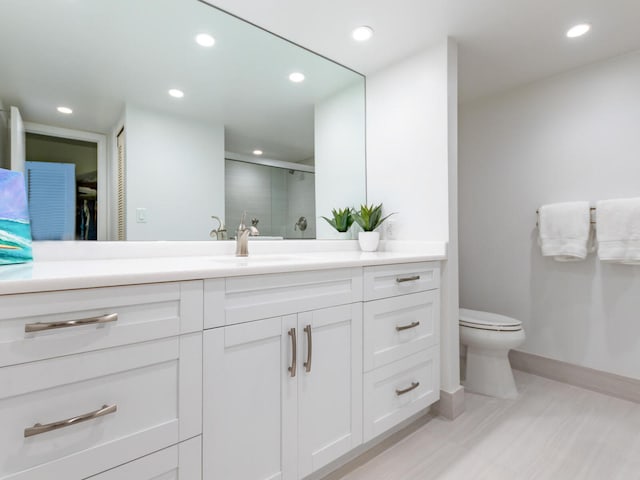 bathroom featuring vanity, hardwood / wood-style flooring, a shower with door, and toilet