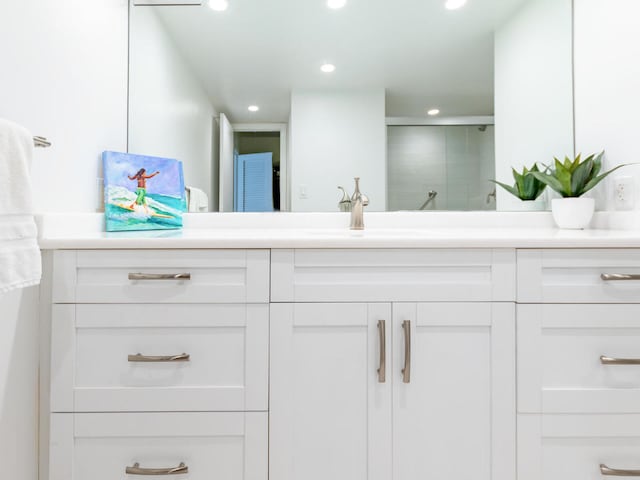 bathroom featuring walk in shower and vanity