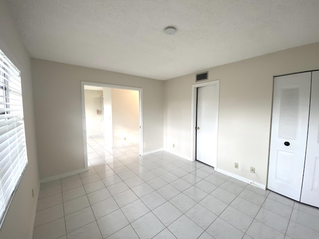 empty room featuring light tile patterned flooring and a textured ceiling