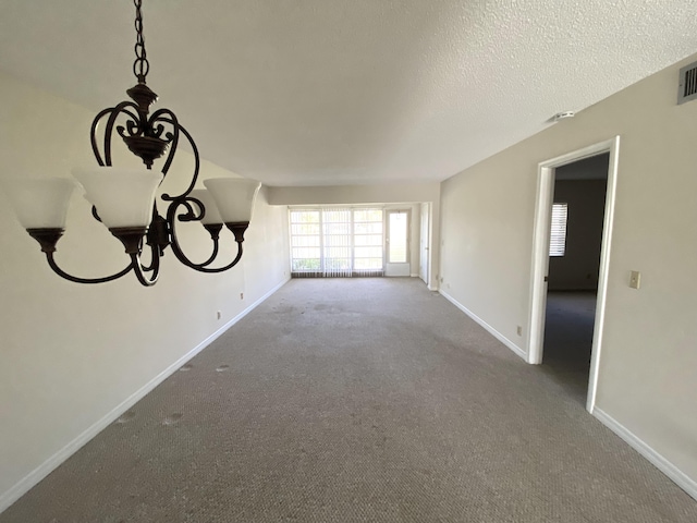 unfurnished living room featuring carpet flooring and a textured ceiling