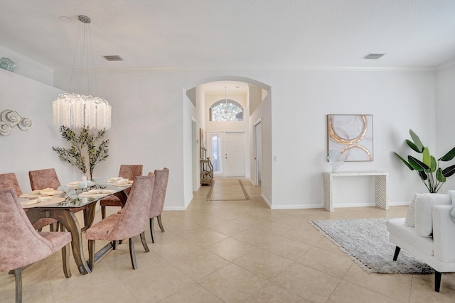 tiled dining area featuring crown molding and a chandelier