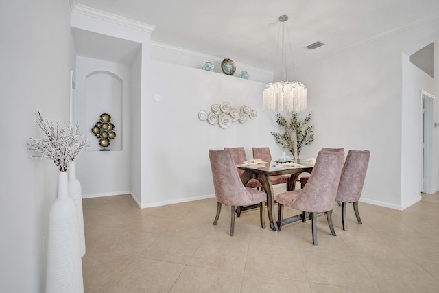 dining space with light tile patterned flooring, ornamental molding, and an inviting chandelier