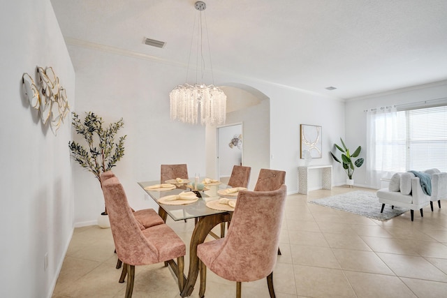 dining room featuring crown molding, a chandelier, and light tile patterned flooring