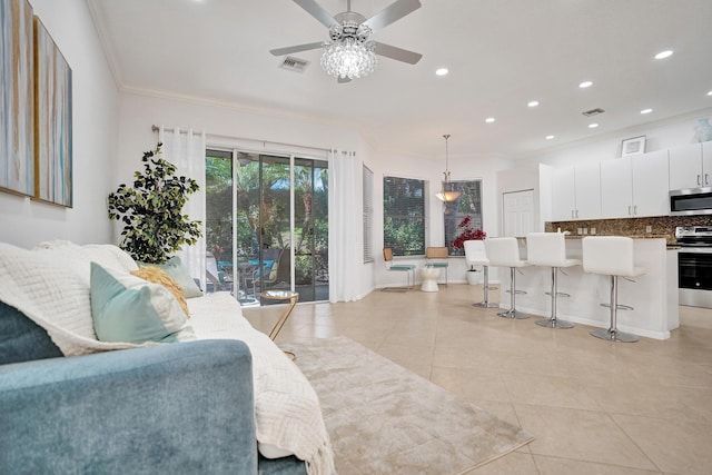 tiled living room with ceiling fan and ornamental molding