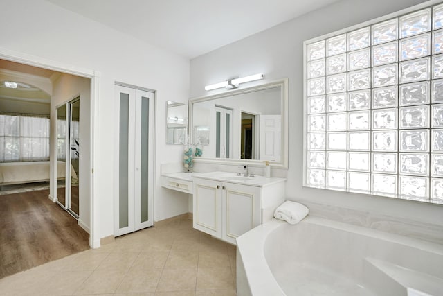 bathroom with tile patterned flooring, vanity, and a bathing tub