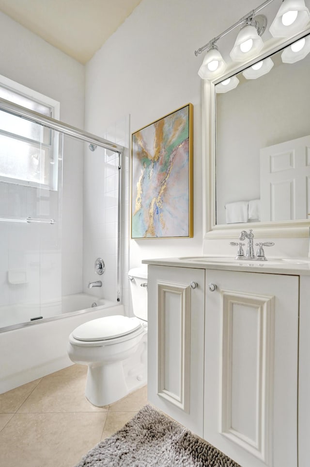 full bathroom with vanity, bath / shower combo with glass door, tile patterned floors, and toilet