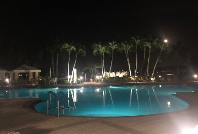 pool at night featuring a patio