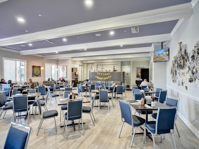 dining space with beamed ceiling and light wood-type flooring