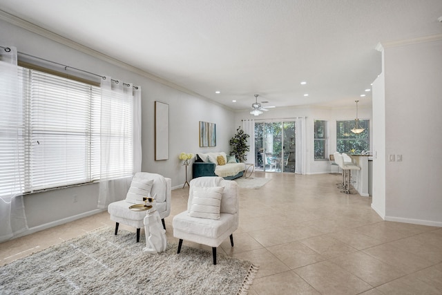 living area featuring light tile patterned floors, ornamental molding, and ceiling fan